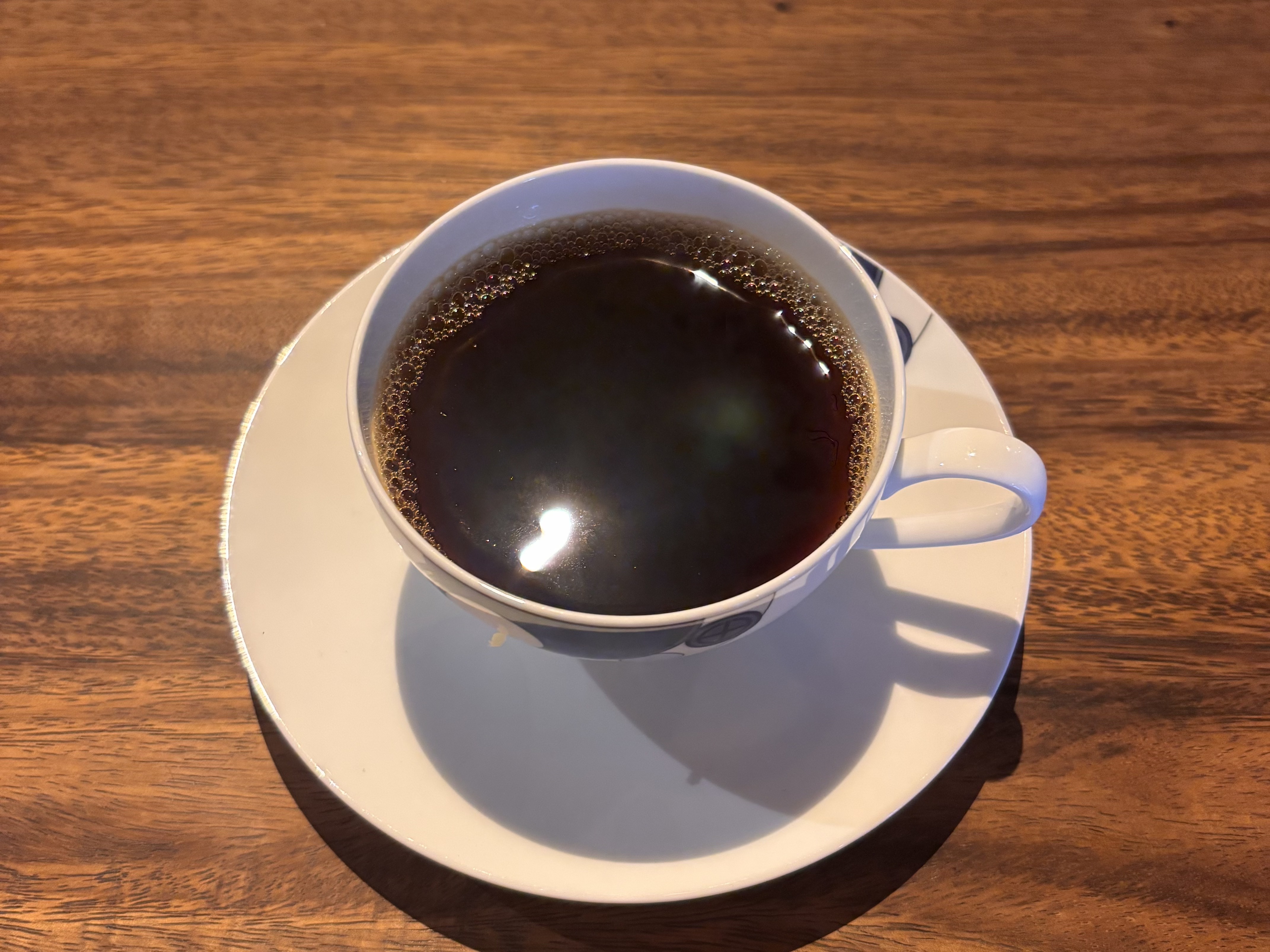 木のテーブルに置かれた一杯のコーヒー